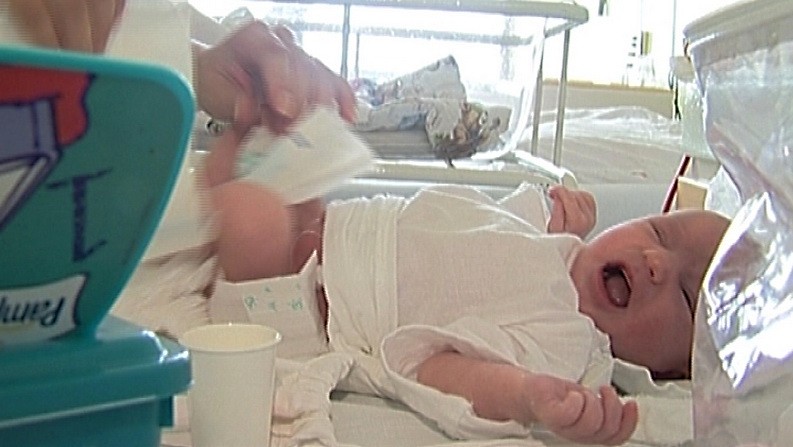 Zdravotná sestra prebaľuje novorodeniatko